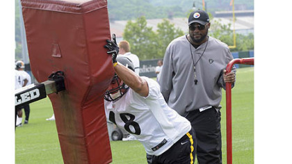 Head coach Mike Tomlin watches rookie tight end David Paulson in a blocking drill during the 2012 OTA sessions.