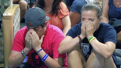 Andrew Hanselman, left, of Bucks County and Maddy Pryor, a senior from Neptune, N.J., react Monday as they listen to a television in the HUB on the Penn State University main campus.