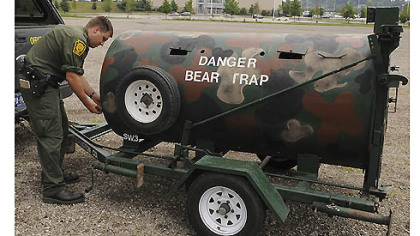 State wildlife conservation Officer Matt Kramer closes a door of a bear trap Monday near the Pittsburgh Mills mall in Frazer. A male bear had been spotted in the area by several people a day after a young female bear was found roaming inside the mall and captured Saturday night.