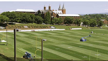 Steeples from the church on the campus of Saint Vincent College are seen above the practice fields where the Steelers arrive for NFL football training camp at the team training facility in Latrobe, Pa.