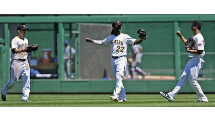 Pirates Alex Presley, Andrew McCutchen and Gorkys Hernandez celebrate after defeating the Cubs Wednesday afternoon.