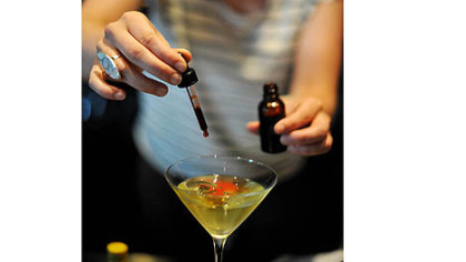 Heather Perkins drops Burlesque Bitters into an O'Shaku cocktail at Spoon.
