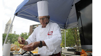 Chef Angelo Galioto scoops a white bean topping onto bruschetta he made in newly renovated Buhl Community Park on the North Side.