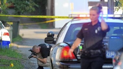 Police investigate the scene where Monaca Officer Alan Shaffer was shot in the leg Wednesday during the foot pursuit in Monaca of a suspect who had earlier robbed a Cricket store. Here, an officer photographs the locations of bullet casings in the alley where Officer Shaffer was shot.  Police have the suspect in custody.