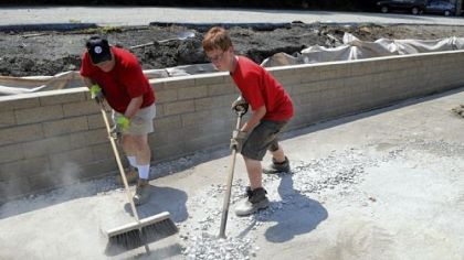 Robert Cortese, left,  helps his son, Robbie Cortese, with his Eagle Scout project, and works on putting the finishing touches on a retaining wall along the parking lot of St. Anne Roman Catholic Church in Castle Shannon.