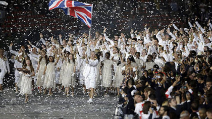 Great Britain's Chris Hoy carries the national flag as confetti surrounds the team during the Opening Ceremony at the 2012 Summer Olympics, Friday, July 27, 2012, in London.