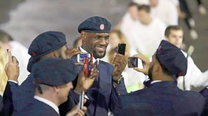 Professional basketball player LeBron James takes pictures with members of the the United States' Olympic team during the Opening Ceremony at the 2012 Summer Olympics, Friday, July 27, 2012, in London.