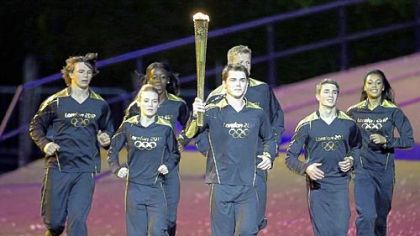Torchbearers run during the Opening Ceremony at the 2012 Summer Olympics, Friday, July 27, 2012, in London.