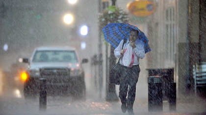 A man walks through Market Square during an evening thunderstorm Thursday.