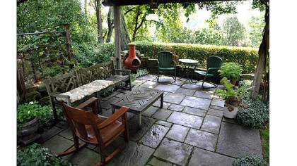 The flagstone patio is shaded by a pergola.