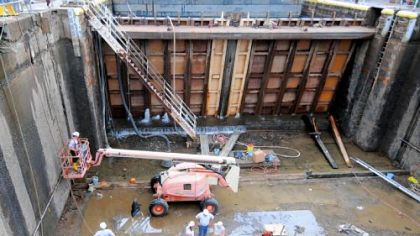 Dwarfed by a temporary dam holding back the Monongahela River, Army Corps of Engineers maintenance crews rebuild the upstream gate seal at the bottom of the 1937-era 35-foot-deep primary chamber of Lock and Dam 4 on the Monongahela River during a three-week closure.