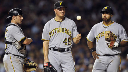 Michael McKenry, left, and Pedro Alvarez, right, watch as starter Erik Bedard tosses the ball in the air after giving up a three-run home run to the Cubs' Anthony Rizzo in the fifth inning Monday in Chicago.