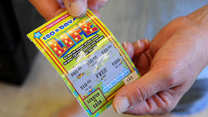 Marlene Snyder of Brighton Heights holds a $1 scratch card she bought today from the Kennedy 7-Eleven.