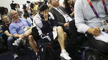 Kim Jiyhun, center, coach of South Korea's disqualified women's doubles badminton players reacts as she attends a news conference of the Badminton World Federation about the Olympic disqualification at Wembley Arena at the 2012 Summer Olympics, Wednesday, Aug. 1, 2012, in London.