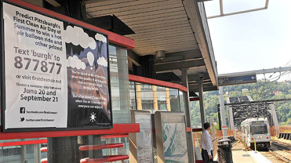 A poster promotes the "First Clean Air Day of Summer" contest at the First Avenue T station, Downtown.