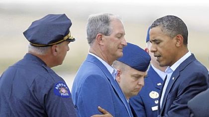 President Barack Obama greets Aurora's Mayor Steve Hogan, center, and police Chief Dan Oates, left, Sunday.