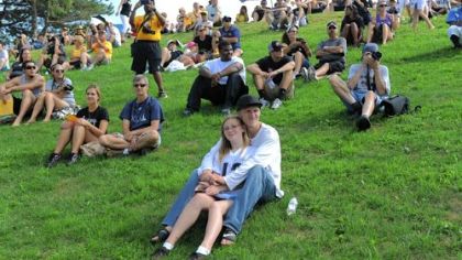Brandy Gruber and Jeremy Hilss of Freeport sit in front on the grassy hillside to watch the first public practice at Steelers training camp at Saint Vincent College in Unity on Friday.