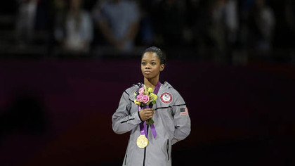 The 16-year-old from Virginia Beach, Va., the first African-American to win the individual gold in the event, displays her medal below.