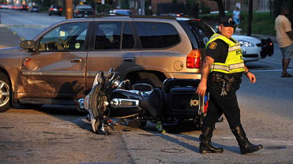 Police direct traffic around the scene of an accident involving an officer riding a motorcycle Thursday on Penn Avenue at its intersection with North Lexington.