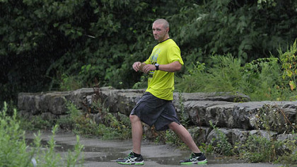 Greg Hamilton, of the North Side, loosens up at the parking area on River Avenue after running the trail in the rain Sunday. Mr. Hamilton says he runs nearly every day and has competed in the Pittsburgh Marathon.