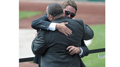 Max Schneider embraces an unidentified friend Saturday during a memorial service for his father, Mark Schneider, at PNC Park. Mark Schneider, former chairman of the Sports & Exhibition Authority and Stadium Authority, died July 29 after a bicycle accident in Maryland.