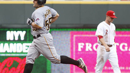 The Pirates' Michael McKenry rounds the bases past Cincinnati Reds shortstop Zack Cozart after McKenry hit a solo home run in the second inning.
