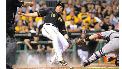 Neil Walker looks for the call as he slides into home safely.