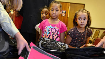 Aaliyah Burke, 6, left, and Olivia Robertson, 6, pick out backpacks during a giveaway Thursday at the Salvation Army's New Kensington Worship and Service Center.