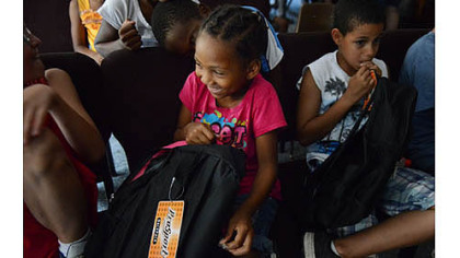 Aaliyah Burke, 6, looks through her new backpack after a giveaway Thursday at the Salvation Army?s New Kensington Worship and Service Center.