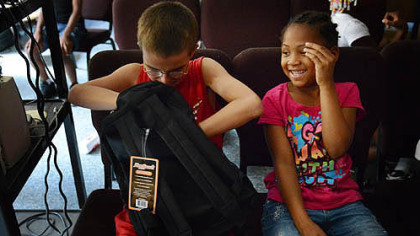 Wesley Filer, 10, and Aaliyah Burke, 6, discuss a school supply trade after a backpack giveaway Thursday at the Salvation Armys New Kensington Worship and Service Center.