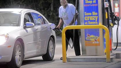 A man pumps gas at Sunoco in McKeesport. Despite rising gas prices, people are still heading to the pumps.