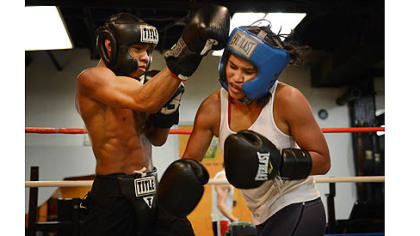 Jennifer Dugwen Chieng takes a hit from Amonte Eberhardt, 21, as they spar Tuesday at the Third Avenue Gym. Ms. Chieng says she usually spars with men as part of her training routine.