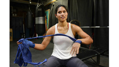 Jennifer Dugwen Chieng unwraps her hands Tuesday after her workout at the Third Avenue Boxing Gym in Downtown Pittsburgh.
