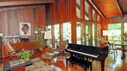 The combined living/dining room runs along the back of the house and measures 13 by 40 feet. It features hardwood floors and the 20-foot-high cathedral ceiling made of redwood.