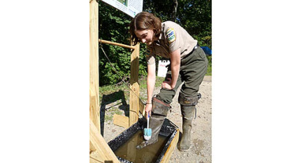 Stacie Hall, assistant manager of Ohiopyle State Park, demonstrates use of a new gear-wash station on the Youghiogheny River.