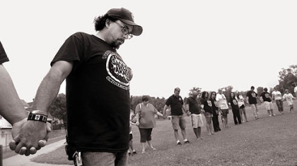 Carmen Capozzi prays in Irwin Park in late July with other members of Sage's Army, a drug awareness advocacy group. He formed the "army" after his son, Sage, 20, died of a heroin overdose in March.