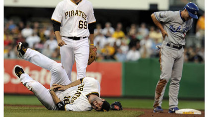 The Pirates' Neil Walker fell to the ground in pain after getting an injury to his right hand after a double play attempt on the Dodgers' Mark Ellis in the first inning at PNC Park Wednesday night.