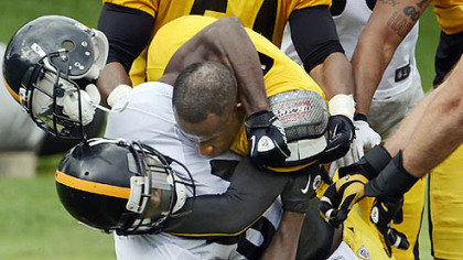 Pittsburgh Steelers cornerback Ike Taylor (gold jersey) wrestles down wide receiver Antonio Brown on Sunday. The fight ensued after Taylor intercepted a pass and roughed up Brown in the end zone.