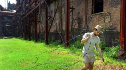 Mark Rawlings, of Polish Hill, a sustainability technician with Zero Fossil, installs wiring for solar panel energy at the furnace, which will replace generators that light the old mill.